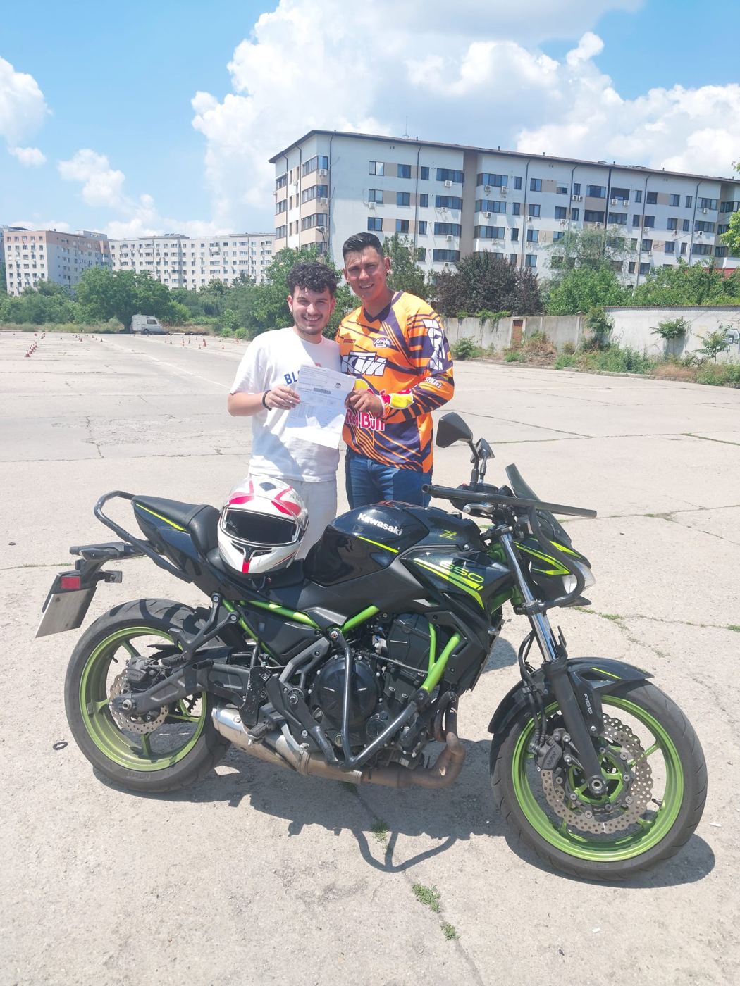Absolvent cu certificatul lângă motocicletă